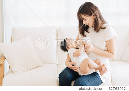 Mom giving milk to her baby in a baby bottle 82763912