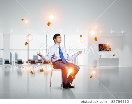 young businessman meditating in the office 82764310