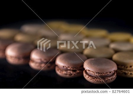 chocolate, coffee, vanilla, lemon and strawberry macaroons on black background 82764601