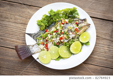 Steamed tilapia fish with chili and lime lemon sauce with herb and Vegetable on plate, Fish steam lime - Thai food 82764923