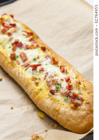 baked baguette filled with cheese and ham 82764955