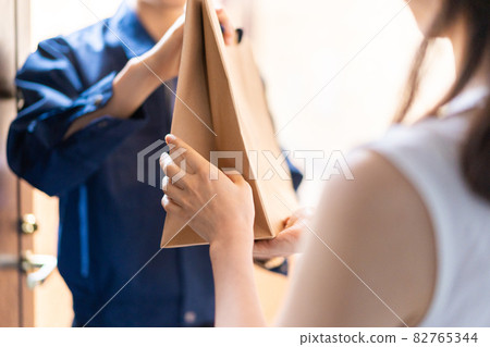 Young woman receiving food delivery 82765344