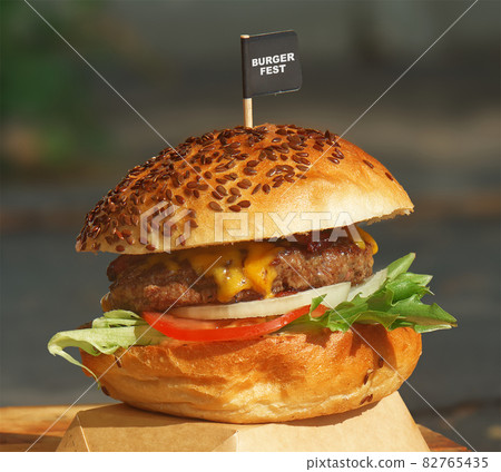 Making yummy fresh burgers at street food market. Freshly prepared burger on display attracts visitors to the farmers street food and wine festival. Making yummy fresh burgers at street food market. Freshly prepared burger on display attracts visitors to the farmers street food and wine festival. 82765435