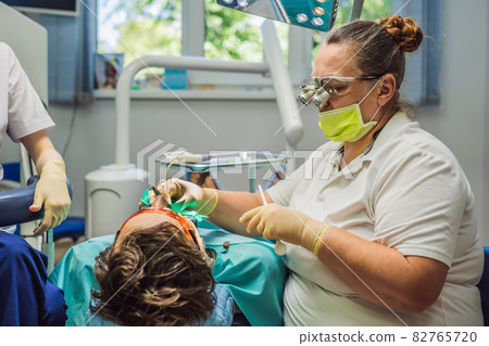 Man having teeth examined at dentists. Dental treatment in dentistry. Appointment at the dentist. lifestyle, real life Man having teeth examined at dentists. Dental treatment in dentistry. Appointment at the dentist. lifestyle, real life 82765720