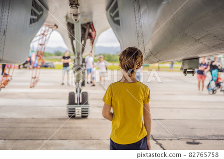 A little boy is studying military equipment. No war A little boy is studying military equipment. No war 82765758