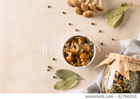 Pickled honey mushrooms served in bowl with bay leaf. 82766938
