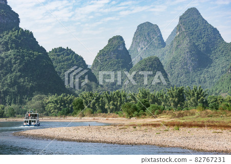 Tourist ship moves along the karst hills. Li River. Tourist ship moves along the karst hills. Li River. 82767231