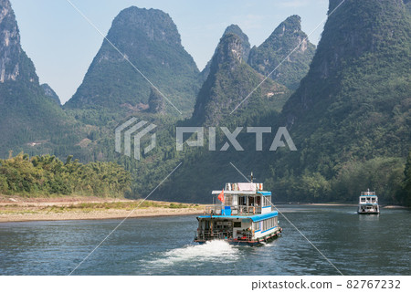 Tourist ship moves along the karst hills. Li River. Tourist ship moves along the karst hills. Li River. 82767232