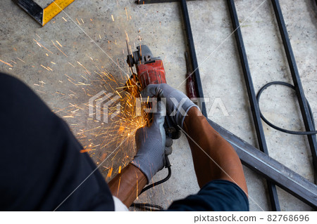 Close up, A man working with angle grinder. Iron gate repair 82768696