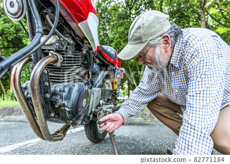 Senior rider inspecting the bike 82771184