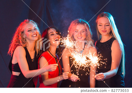 Birthday party, new year and holidays concept - Group of female friends celebrating holding sparklers 82773033