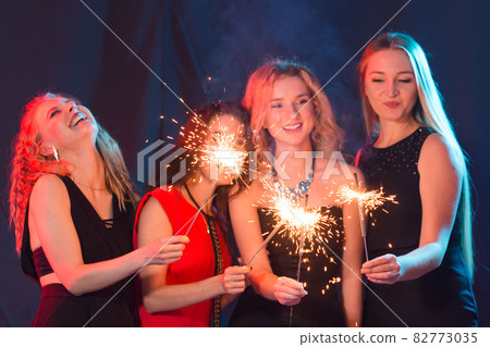 Birthday party, new year and holidays concept - Group of female friends celebrating holding sparklers 82773035