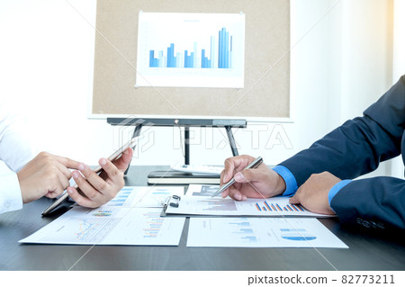 Two business leaders talk about charts, financial graphs showing results are analyzing and calculating planning strategies, business success building processes Two business leaders talk about charts, financial graphs showing results are analyzing and calculating planning strategies, business success building processes 82773211