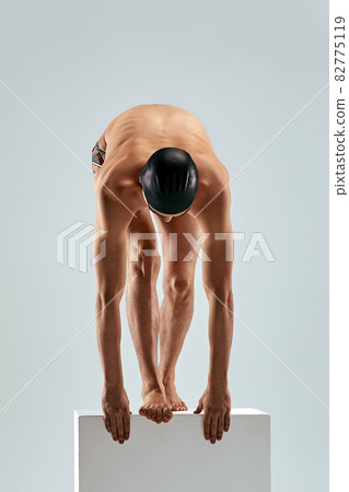 Portrait of a swimmer who is preparing for a jump. The concept of swimming and water games. Front view. Mixed media 82775119