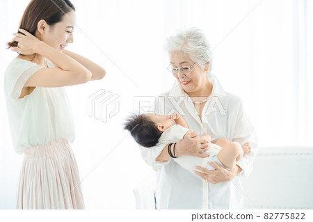 Senior women hugging babies and women watching over Senior women hugging babies and women watching over 82775822