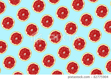 Fresh grapefuit slices seamless pattern over blue background, top view Fresh grapefuit slices seamless pattern over blue background, top view 82775904