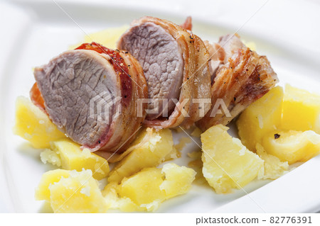pork roll wrapped in bacon with potatoes 82776391
