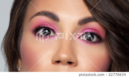 Beautiful macro of expressive brown eyes with fashionable pink smoky shadows, extremely long eyelashes. Cosmetology, eyebrow correction, eyelash extensions, makeup, cosmetics, eyesight, contact lenses Beautiful macro of expressive brown eyes with fashionable pink smoky shadows, extremely long eyelashes. Cosmetology, eyebrow correction, eyelash extensions, makeup, cosmetics, eyesight, contact lenses 82776634