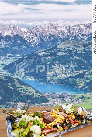 Traditional austrian food experience against Zell am see( lake) town with Alps in Austria, Salcburgerland Traditional austrian food experience against Zell am see( lake) town with Alps in Austria, Salcburgerland 82777316