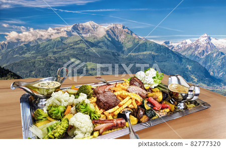 Traditional austrian food experience over Zell am see village with Kitzsteinhorn peak ( Tauern Alps) in Austria 82777320