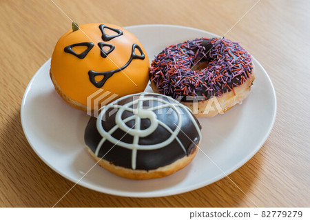 Eat donuts at a Halloween party 82779279