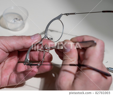 Installation of nose pads in glasses. A male technician repairs broken glasses 82781003