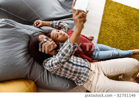 Smiling teacher and schoolboy making selfie on mobile phone 82781146