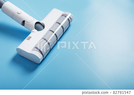 White vacuum cleaner brush on a blue background, top view. Cleaning concept 82781547