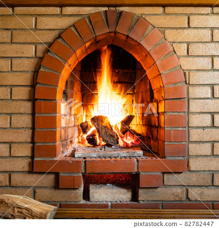 front view of brick fireplace with burning logs 82782447