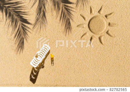 Aerial view of one sunbed, lounge, shadow of a palm tree branch draw sun on private sand beach. Summer and travel concept. Minimalism 82782565