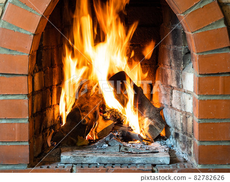 front view of fire in brick fireplace in house 82782626