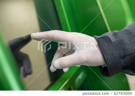 Men hand in protective rubber gloves touches the screen of an ATM during coronavirus epidemic. Pandemic. 82783009