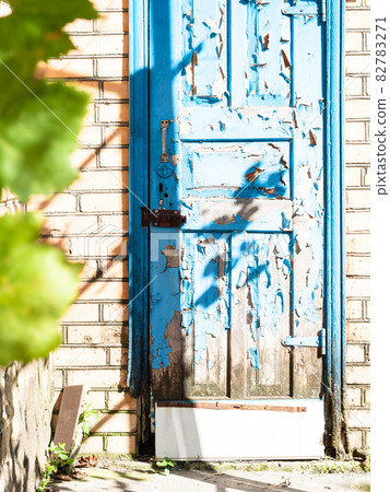 old wooden outdoor door with peeling blue paint old wooden outdoor door with peeling blue paint 82783271