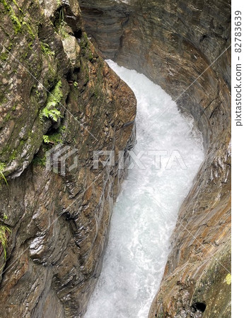 wooden walkpath as bridge over cascading waterfall 82783639