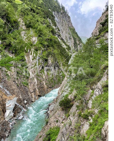 wanderpath in the rocks near a wild river 82783640