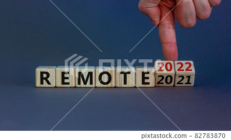 Planning 2022 remote new year symbol. Businessman turns wooden cubes and changes words 'remote 2021' to 'remote 2022'. Beautiful grey background, copy space. Business, 2022 remote new year concept. 82783870