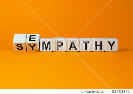 Erom sympathy to empathy. Turned cubes and changed the word 'sympathy' to 'empathy'. Beautiful orange background. Copy space. Psychological, sympathy and empathy concept. Erom sympathy to empathy. Turned cubes and changed the word 'sympathy' to 'empathy'. Beautiful orange background. Copy space. Psychological, sympathy and empathy concept. 82783871