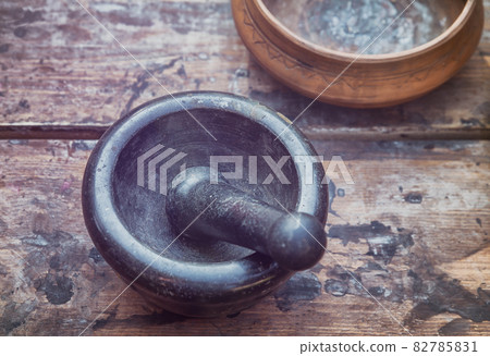 mortar & pestle black stone on a wooden table, traditional utensils for alchemy mortar & pestle black stone on a wooden table, traditional utensils for alchemy 82785831
