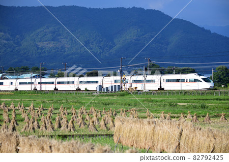 Odakyu Romance Car VSE Limited Express Train running through rice fields after harvesting rice 82792425