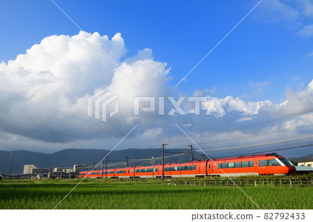 Odakyu Romance Car GSE Limited Express Train running through rice fields after harvesting rice 82792433