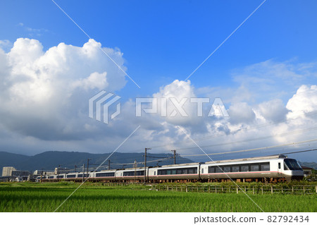 Odakyu Romancecar EXE-α Limited Express train running through rice fields after harvesting rice 82792434
