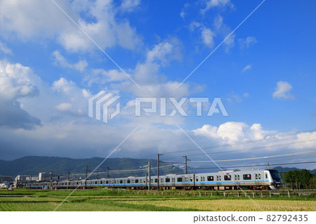 Odakyu Line 5000 series running through rice fields after harvesting rice 82792435