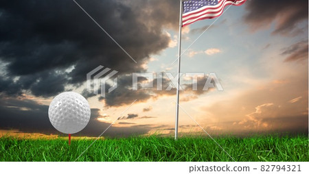Composition of golf ball in grass on red tee, american flag and copy space 82794321