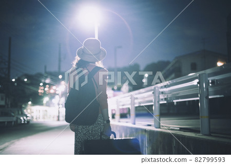 一個女人提著手提箱走路的背影 82799593