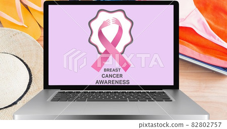 Composition of pink ribbon logo and breast cancer text on the laptop screen Composition of pink ribbon logo and breast cancer text on the laptop screen 82802757