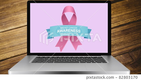 Composition of pink ribbon logo and breast cancer text on the laptop screen 82803170