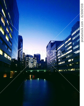 A building overlooking the river on a summer night A building overlooking the river on a summer night 82806508