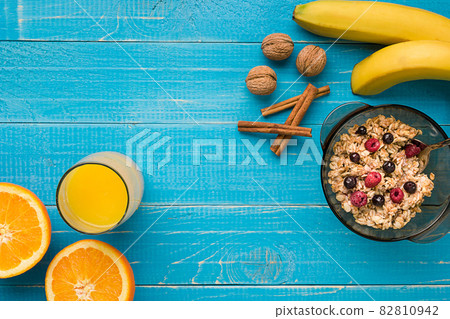oatmeal porridge with banana, kiwi fruit, nuts and honey in a bowl with egg for healthy breakfast on rustic wooden background. top view oatmeal porridge with banana, kiwi fruit, nuts and honey in a bowl with egg for healthy breakfast on rustic wooden background. top view 82810942