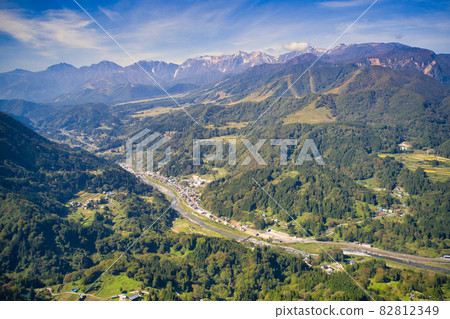 Superb view of Ushirotateyama mountain range and Otari village seen from the view town Otari village, Nagano prefecture (aerial view by drone) 82812349