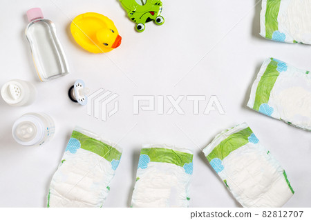 Babies goods diaper, baby powder, cream, shampoo, oil on white background with copy space. Top view or flat lay. 82812707